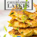Low Carb Cauliflower Latkes stacked on a plate and topped with sour cream