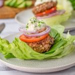 Keto Lamb & Halloumi Burgers in a lettuce wrap topped with tomato and onion