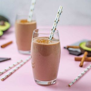 Keto Chocolate Avocado Smoothie in a glass on a pink table