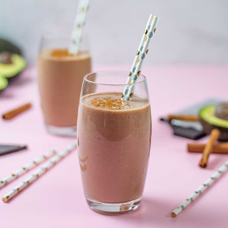 Keto Chocolate Avocado Smoothie in a glass on a pink table