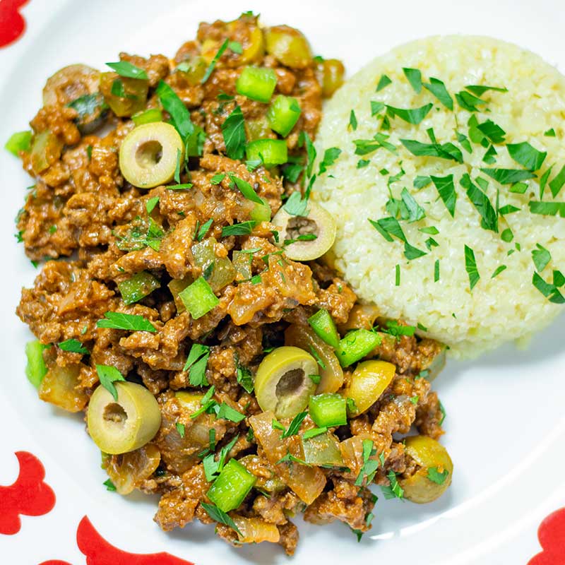 Our Delicious Cuban Style Ground Beef Recipe Keto Cuban Picadillo on a plate with cauliflower rice