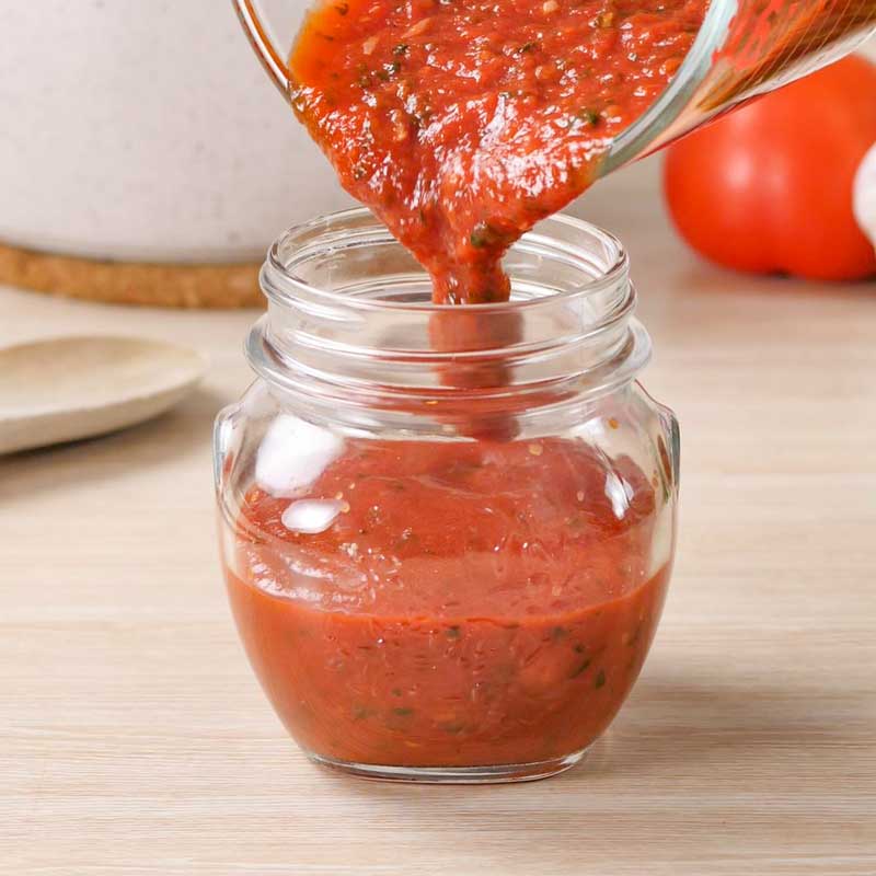 Keto Marinara Sauce Ingredients being poured into a glass jar