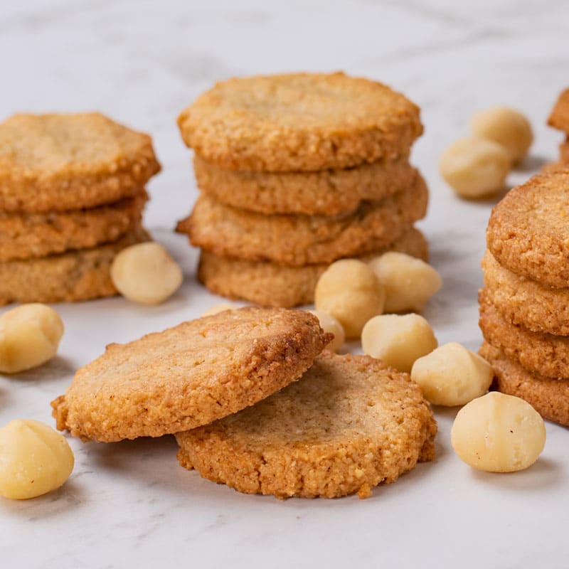 Keto Macadamia Cookies stacked in a pile on a marble table