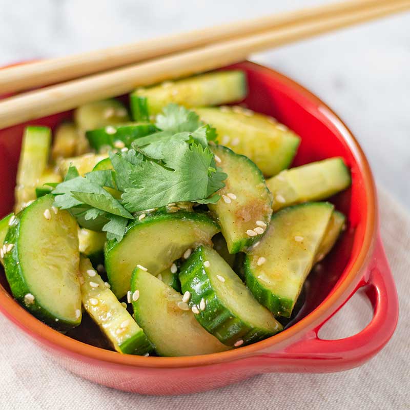 Chinese cucumber salad in a red salad bowl.