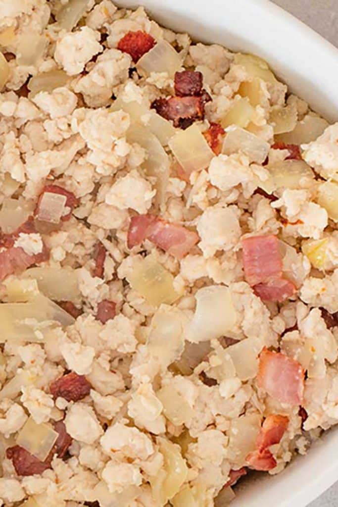 Keto chicken, cheese and bacon casserole ingredients in a white casserole dish.