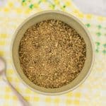 Keto poultry seasoning in a bowl on a yellow matt on a table.