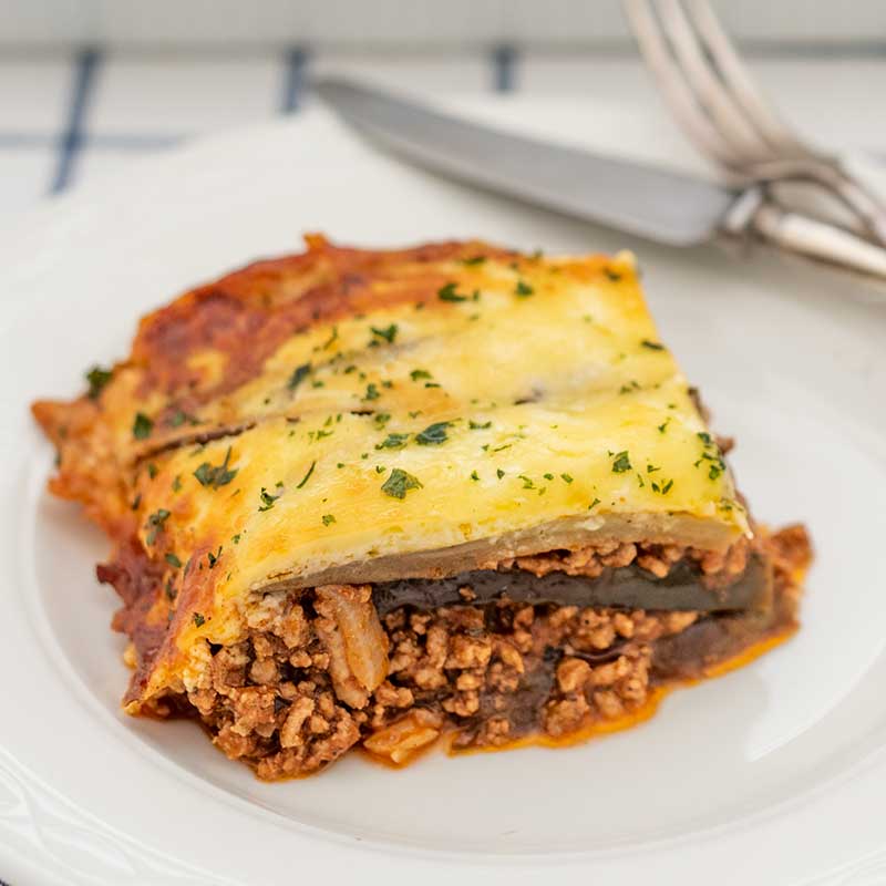 Image of Keto Moussaka on a white plate with a silver knife and fork in the background