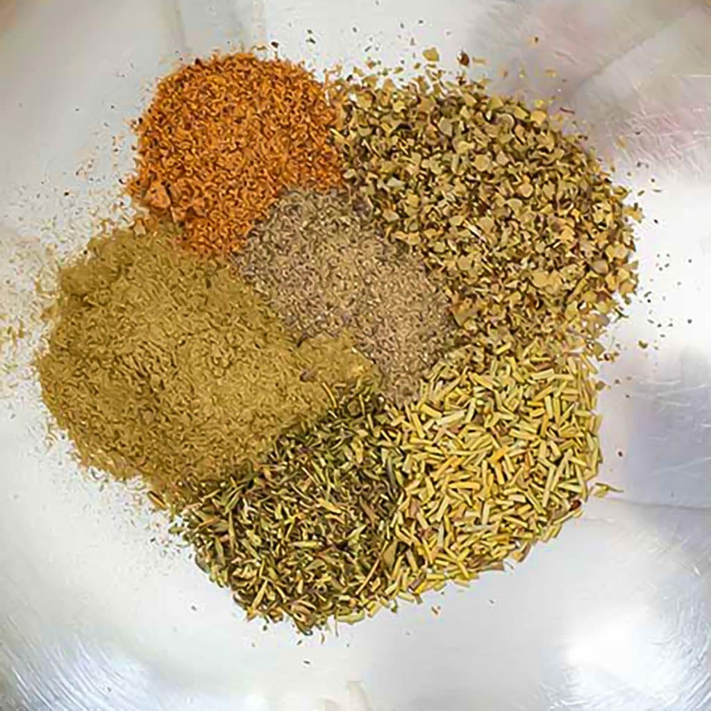 Homemade poultry seasoning ingredients. Sage, thyme, marjoram, rosemary, nutmeg, white pepper.