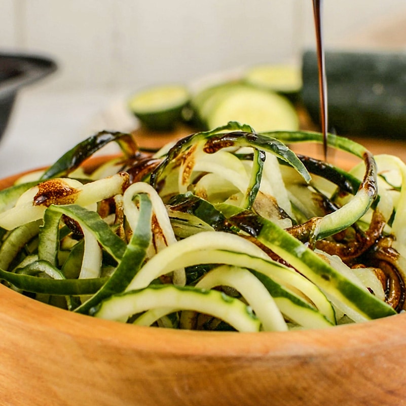 Keto Cucumber Noodle Salad with dressing poured over