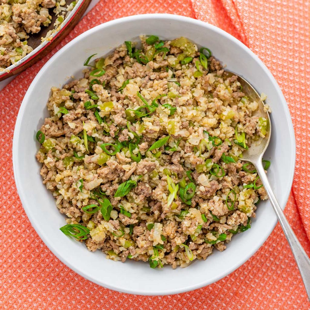 Keto Dirty Rice in a white bowl on an orange napkin