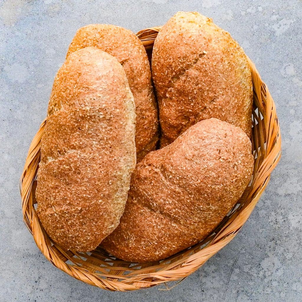 Keto sub rolls in a basket on a grey table