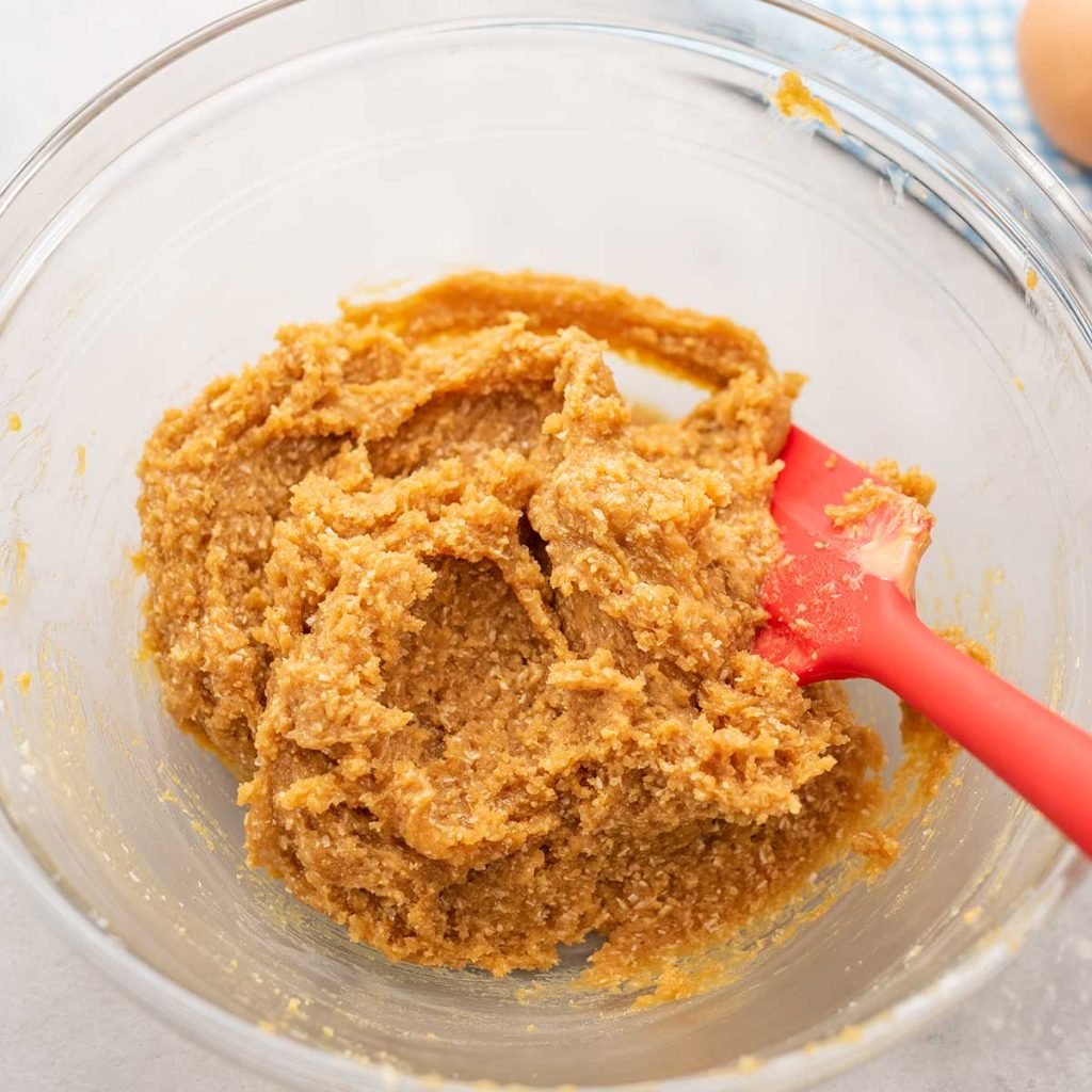 Keto Peanut Butter Cookie dougn in a glass bowl with a red spatula