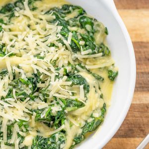 Keto Creamed Spinach in a white bowl on a wood background