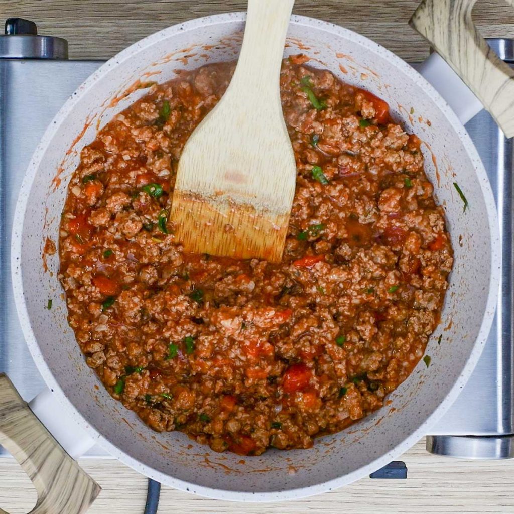 Keto Sausage pasta ingredients simmering in a white saucepan