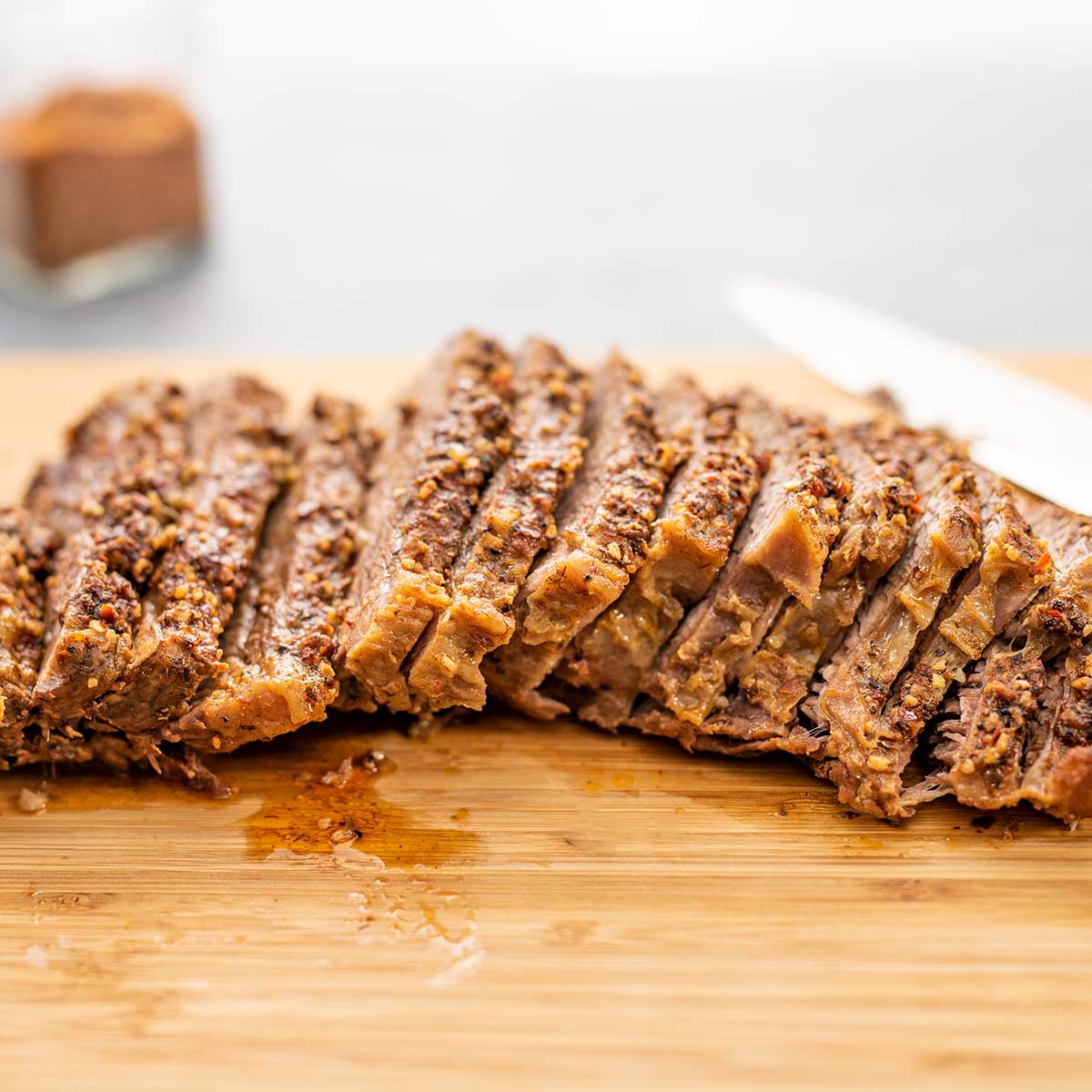 Slow Cooker Keto Tri Tip slices on a wooden board