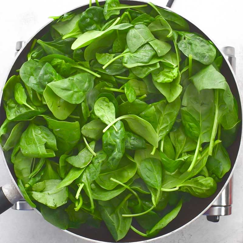 Spinach sauteing in a pan for to make Keto Creamed Spinach