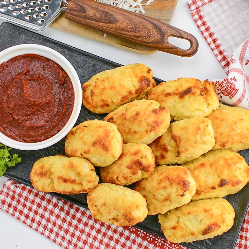 Keto Cauliflower Tots on a platter with marinara sauce