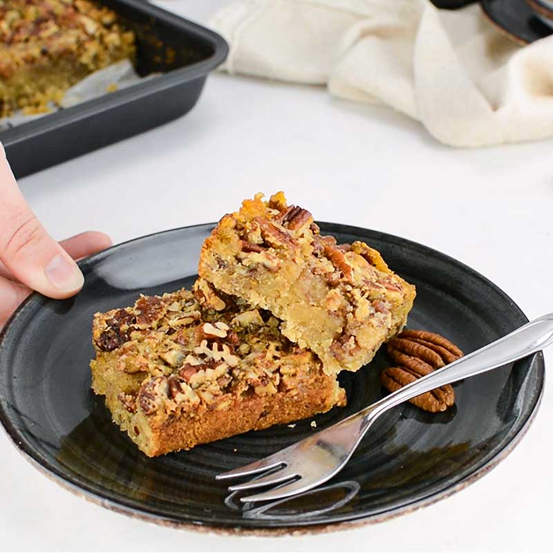 Keto Pecan Bars on a black plate on a white table