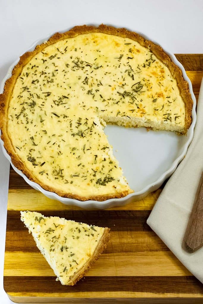 Keto cheese pie on a plate with a slice cut out.