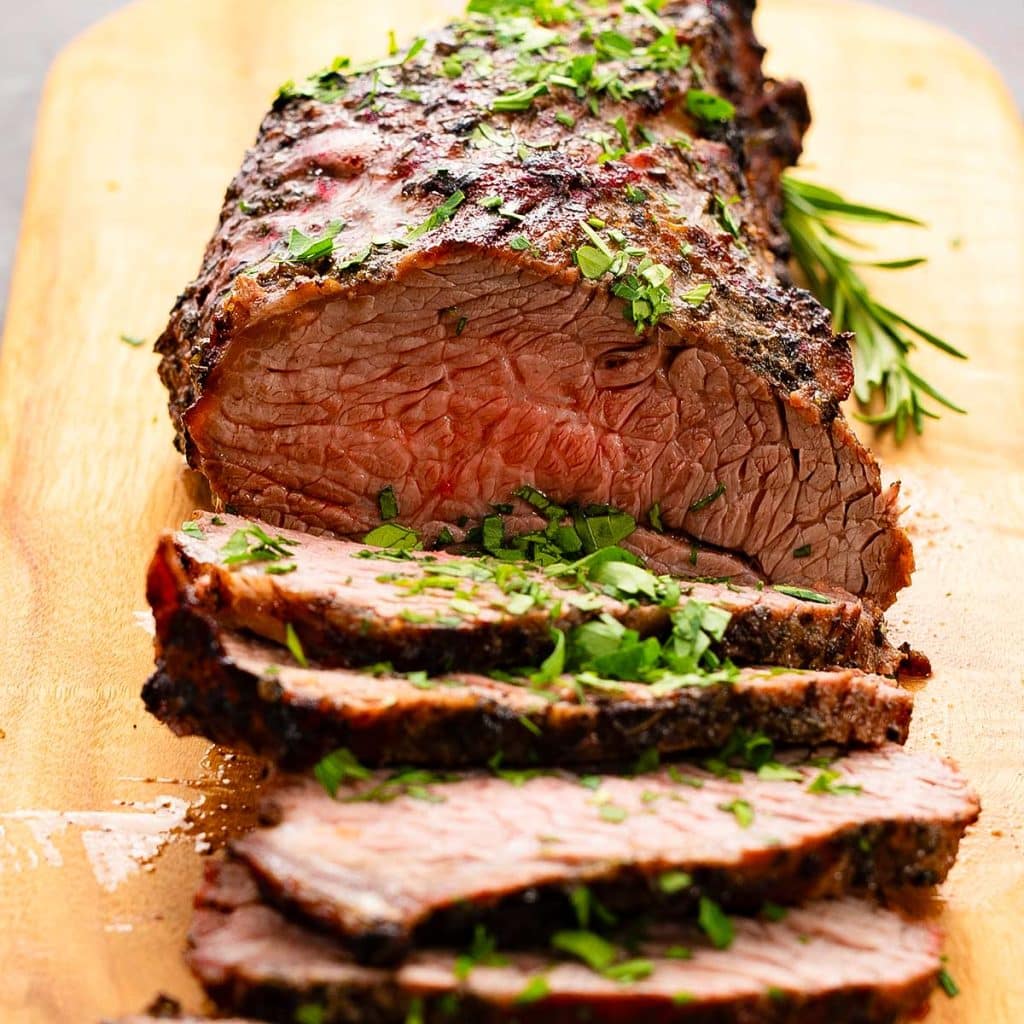 Grilled tri tip sliced on a chopping board.