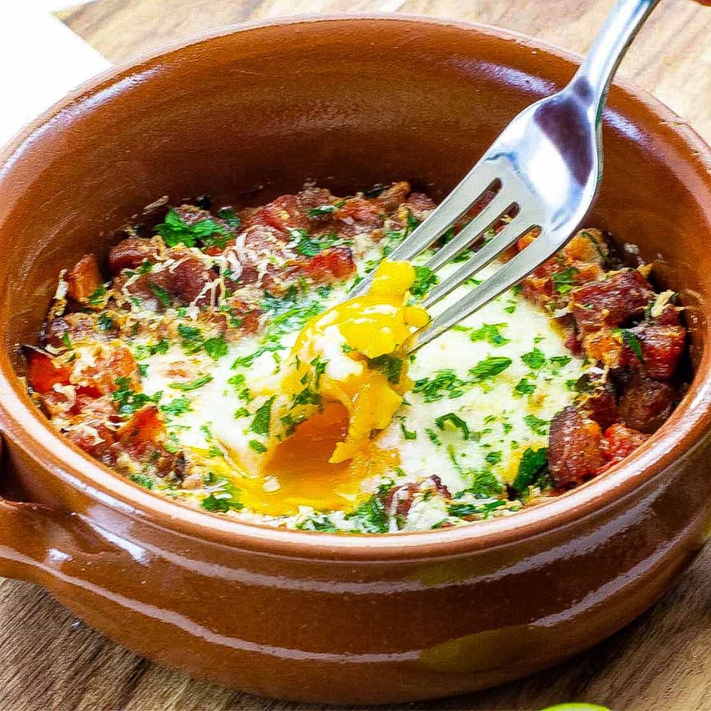 Spanish baked eggs in a brown bowl.