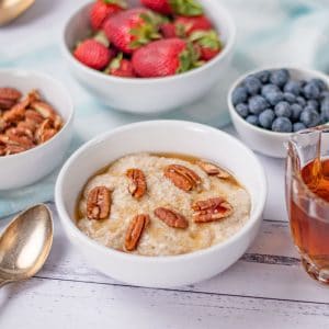 Keto Oatmeal in a bowl topped with pecans and maple syrup