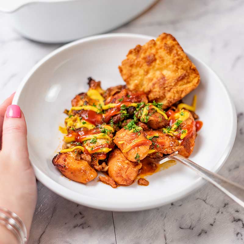 Keto Chili Cheese Dog Casserole in a bowl with a cheddar biscuit