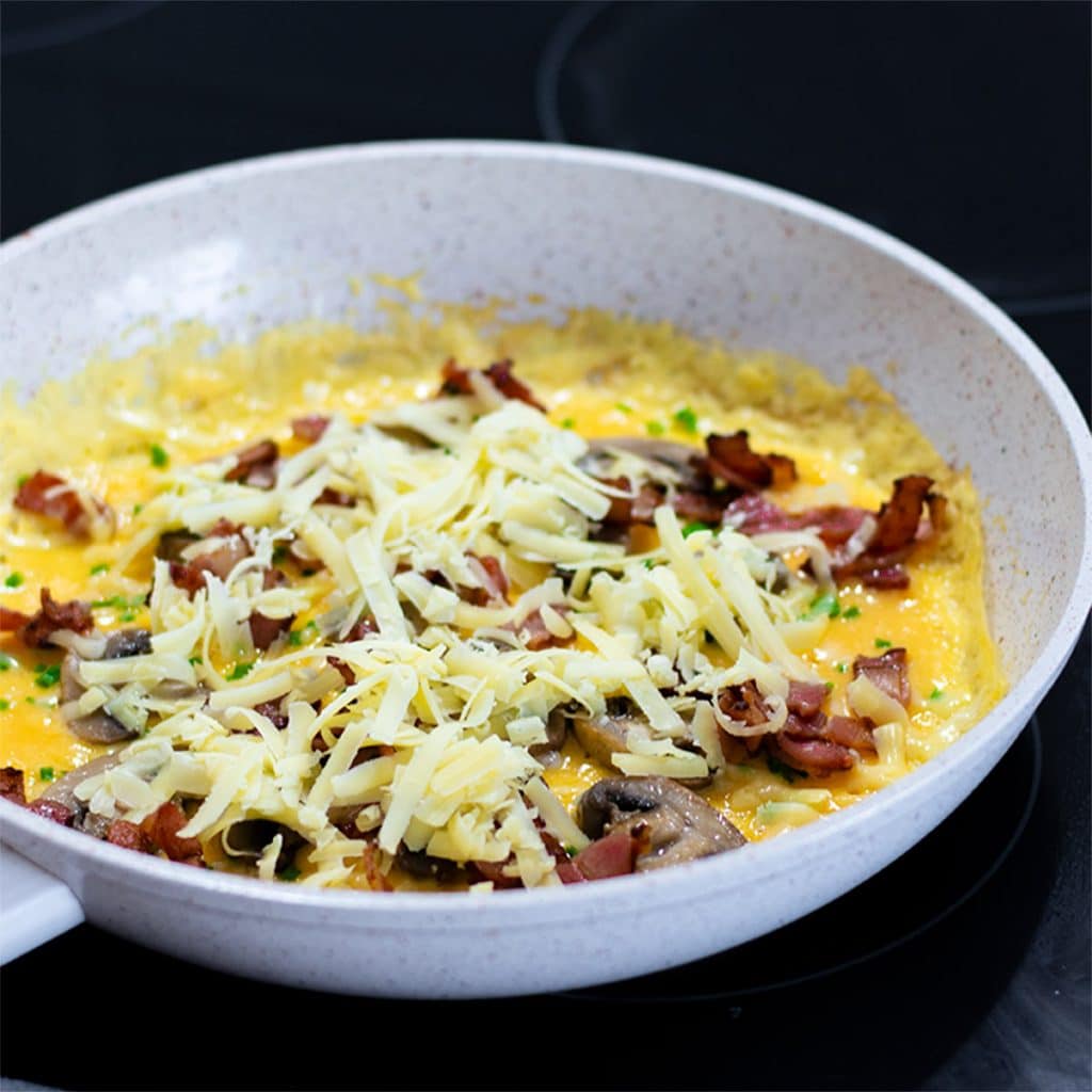 Keto omelet ingredients in a frying pan.
