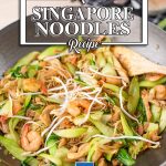 Keto Singapore Noodles in a wok with a wooden utensil tucked under the noodles on the right.
