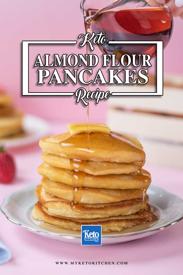 A stack of Keto Almond Flour Pancakes topped with butter and being drizzled with sugar-free maple syrup