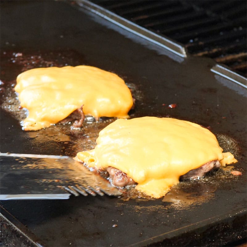 Keto Beef Burger Patties topped with cheese on the grill