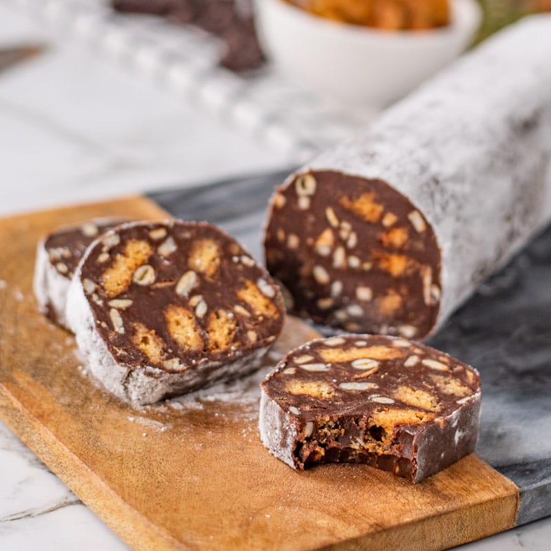 Keto Chocolate Salami sliced on a wooden and marble board