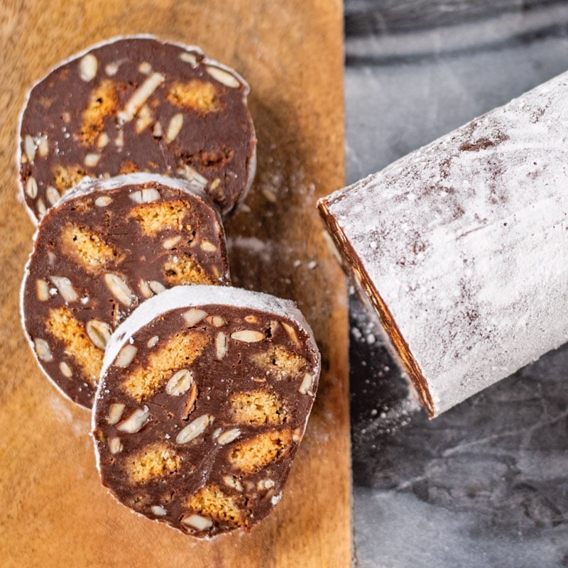 Keto Chocolate Salami sliced on a wooden and marble board