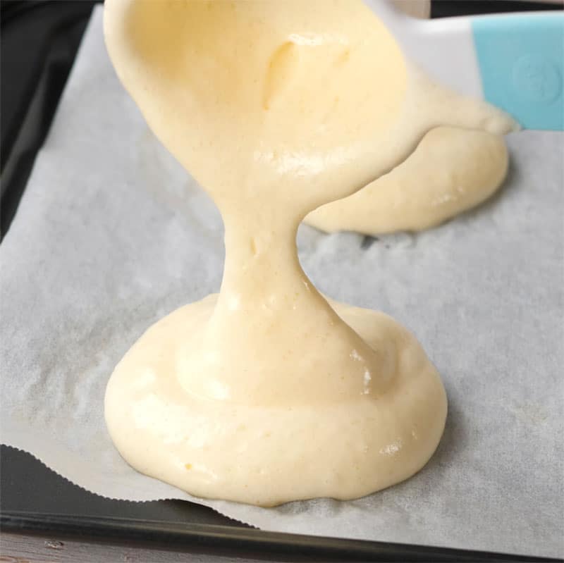 Keto Egg Bread Ingredients being portion onto a cookie sheet lined with parchment paper.