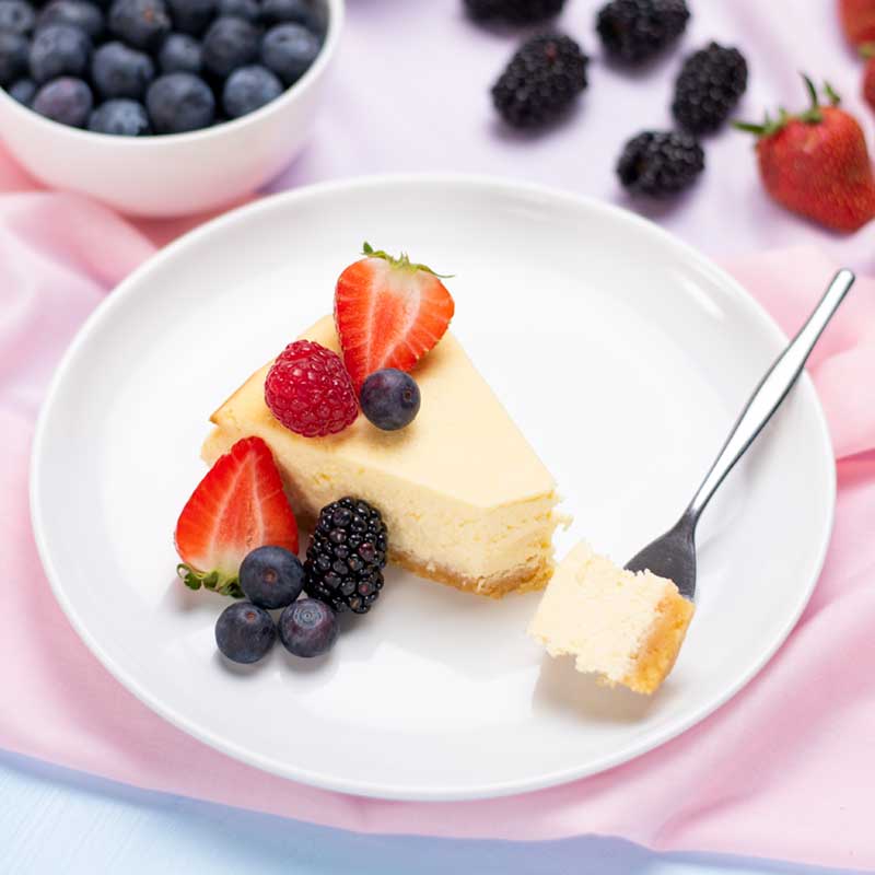 A slice of Keto Cheesecake topped with berries on a plate.