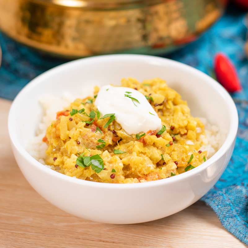 Keto Cauliflower Dal in a bowl topped with a dollop of yogurt.