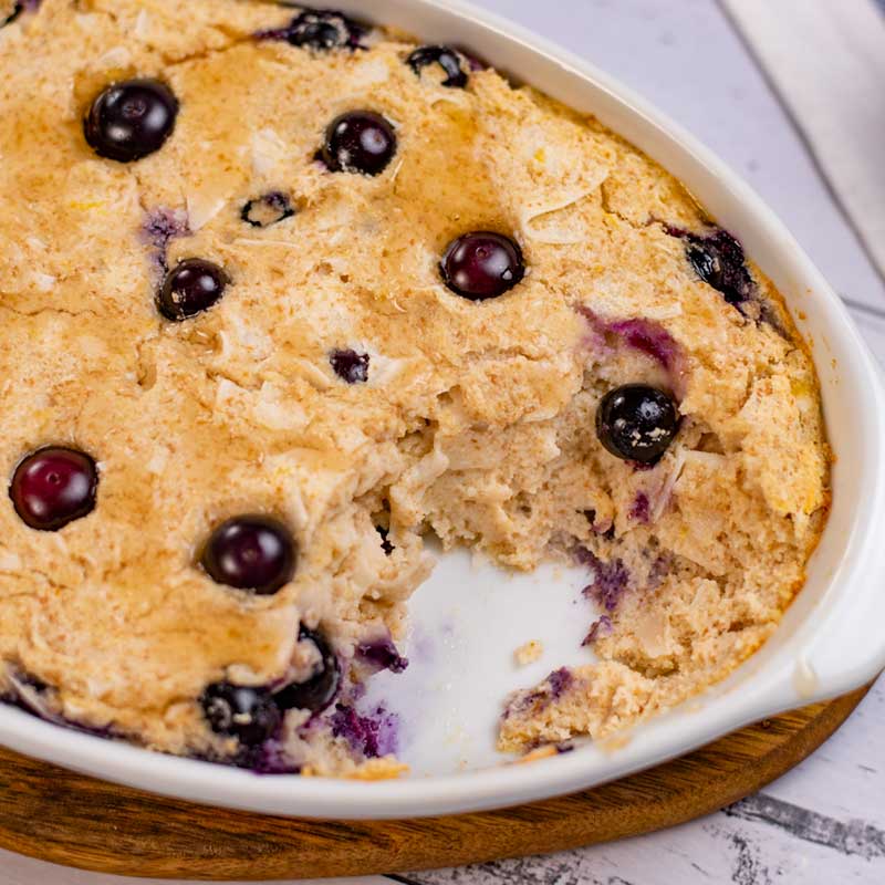 Keto Blueberry Baked Oatmeal is a baking dish with a spoonful removed.