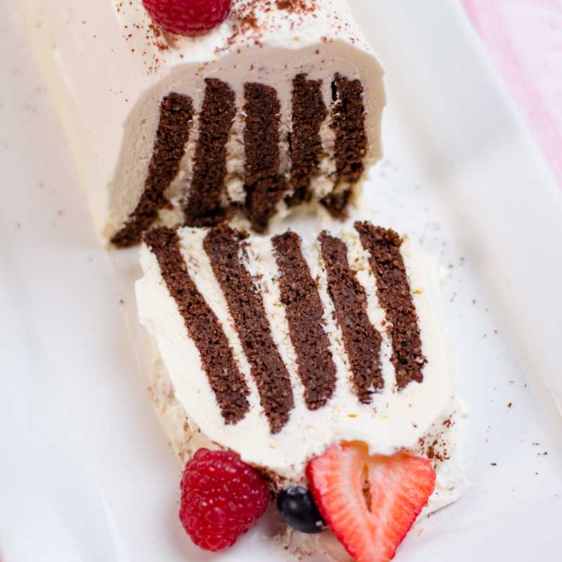 Keto Chocolate Cookie Cake with a slice cut off to reveal the striped inside.