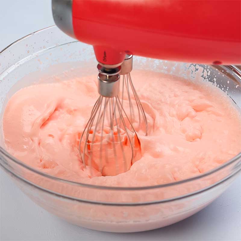 Keto Strawberry Whipped Jello Ingredients being whipped in a mixing bowl.