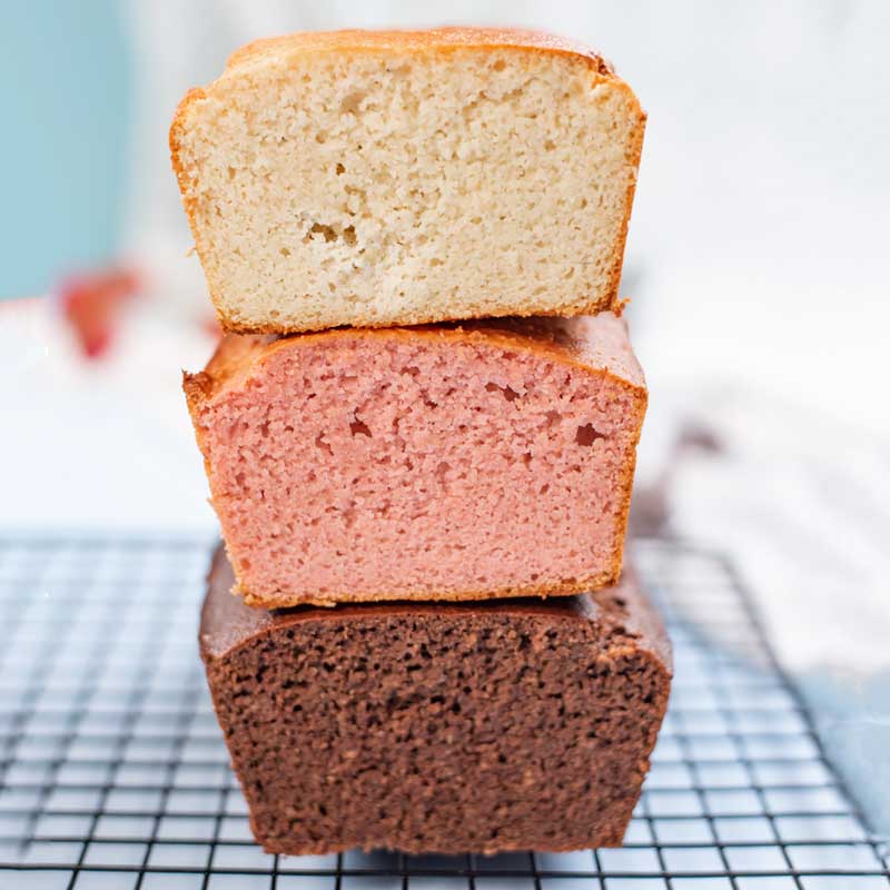 Loaves of Chocolate, Strawberry, and Vanilla Keto Ice Cream Bread stacked on top of each other.