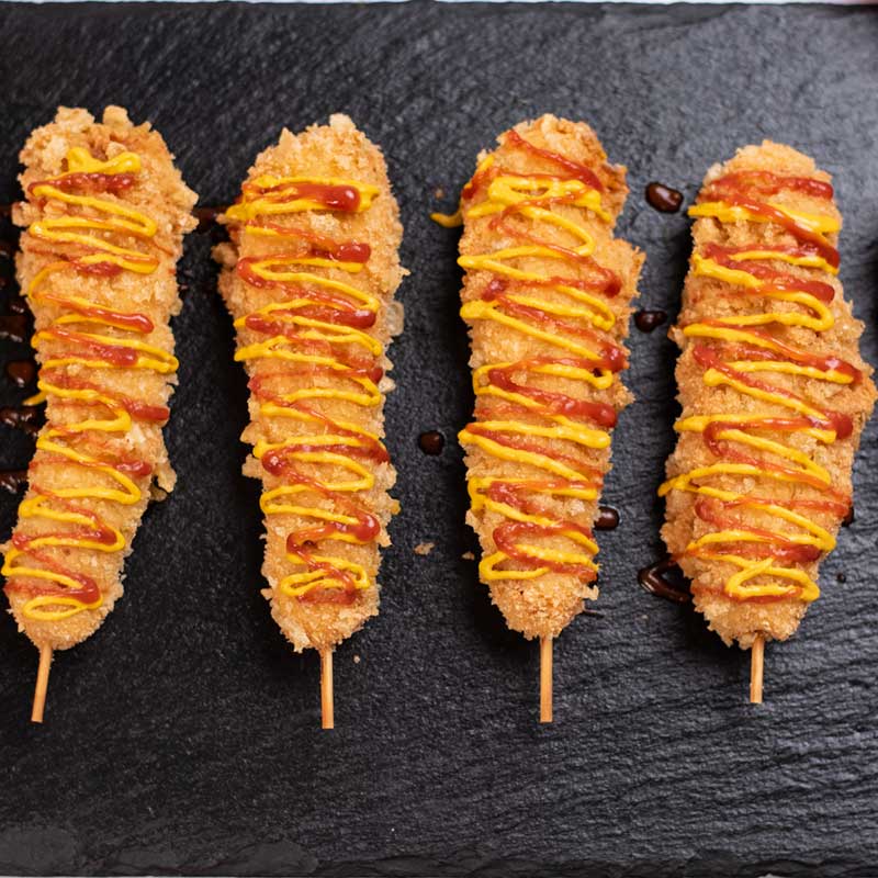 Keto Korean Corn Dogs covered with mustard and ketchup.