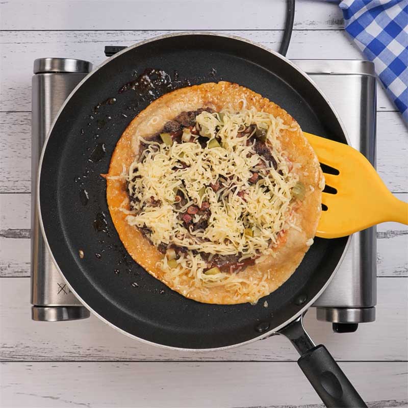 Keto Burger Quesadillas being flipped in a frying pan.