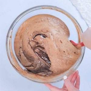 Keto Flourless Cake Ingredients being mixed in a glass bowl.
