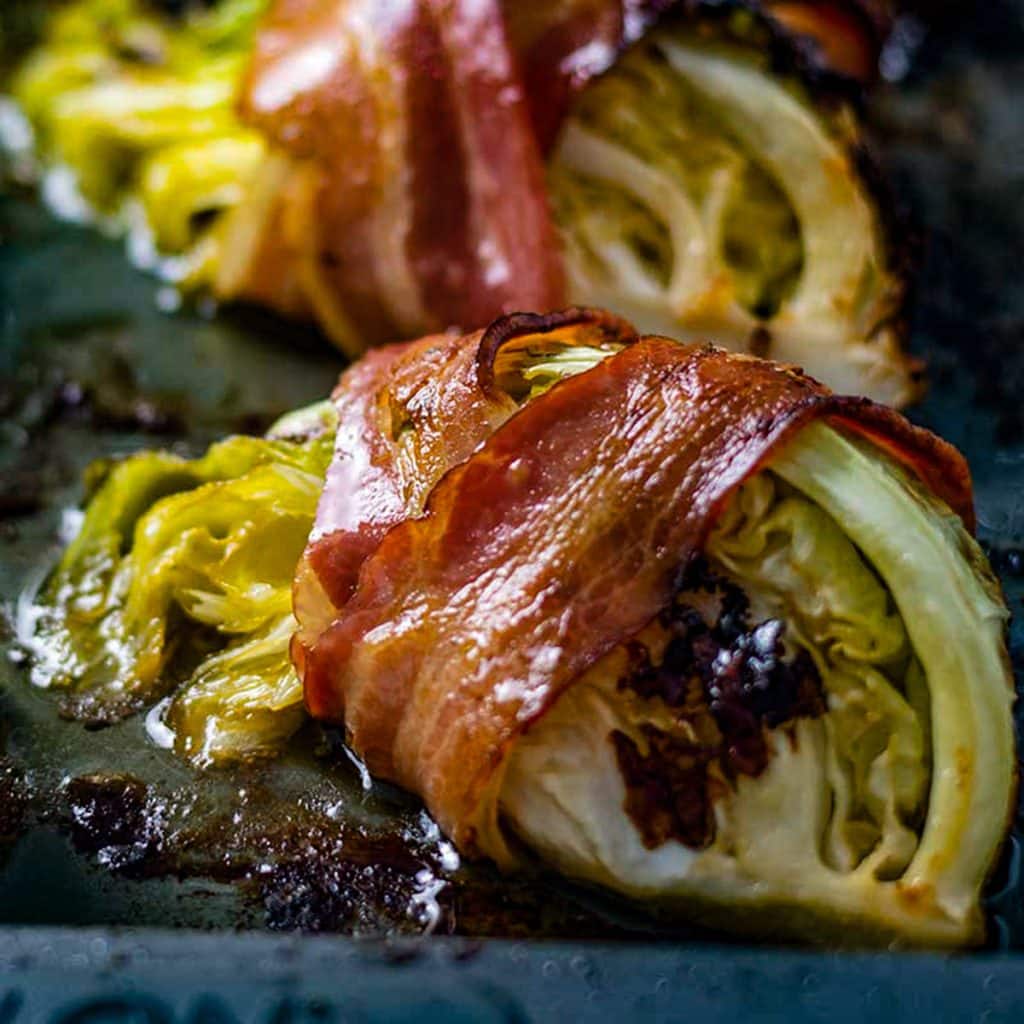 Keto bacon wrapped cabbage on a baking tray.