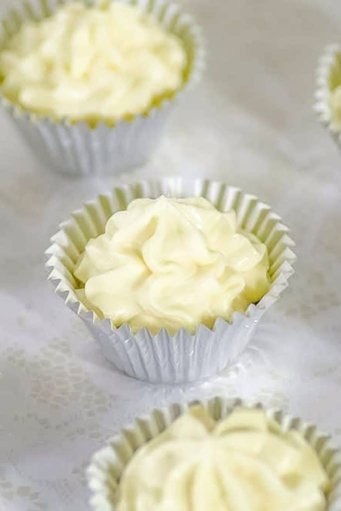 Three cheesecake fat bombs on a sheet.