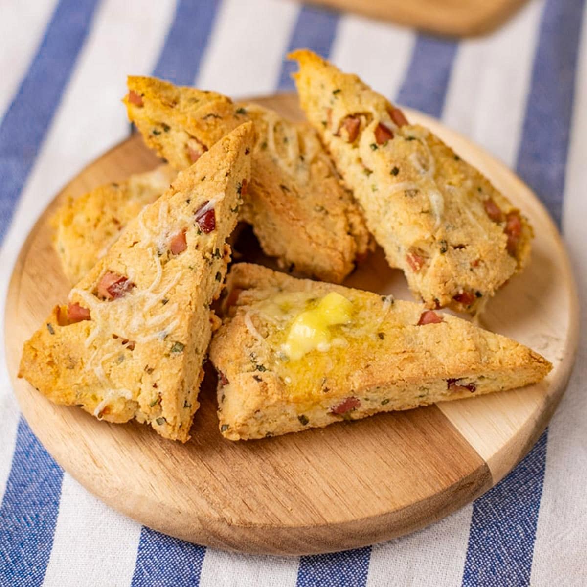 Keto scones with ham and cheese on a serving plate.