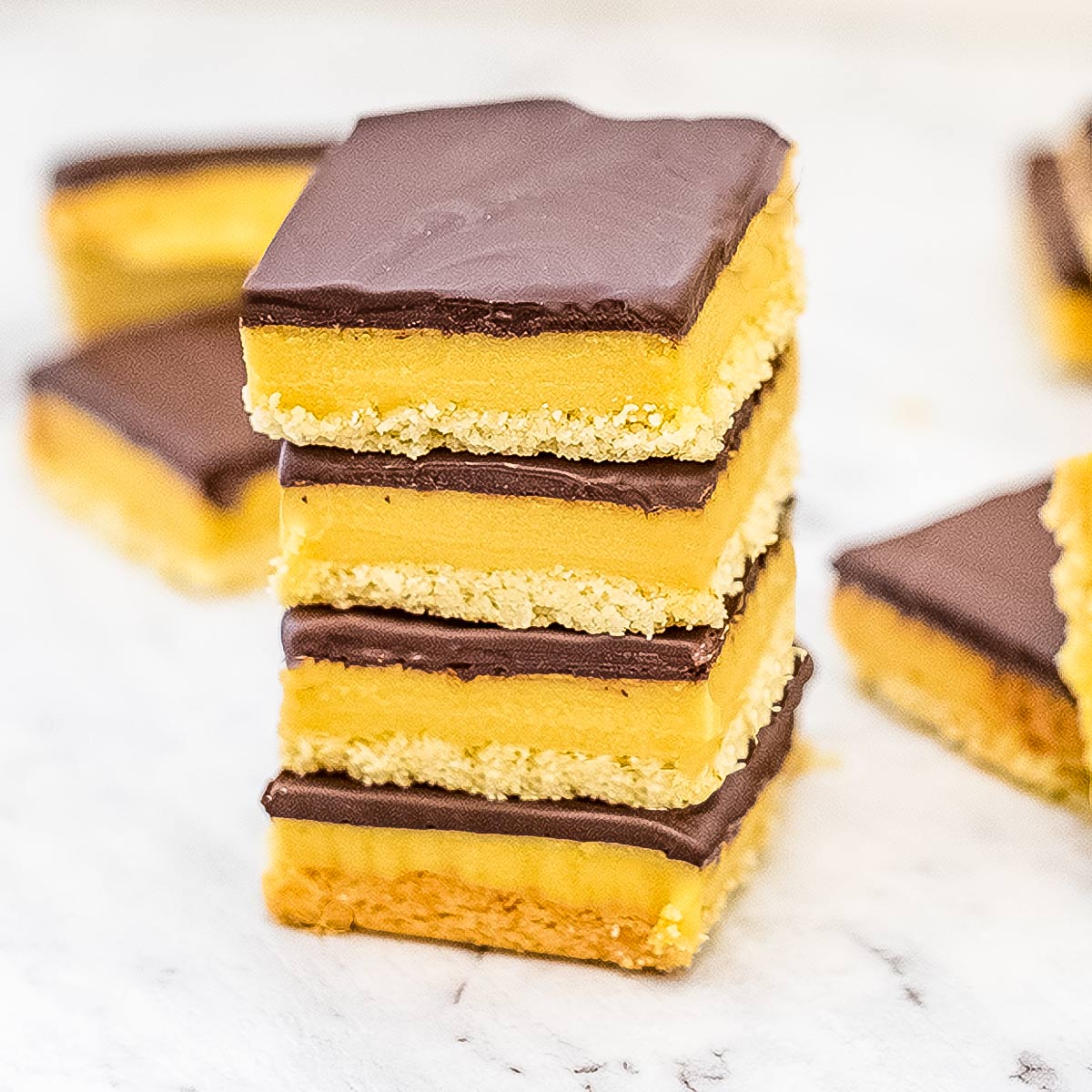 Keto caramel slice stacked on top of one another..
