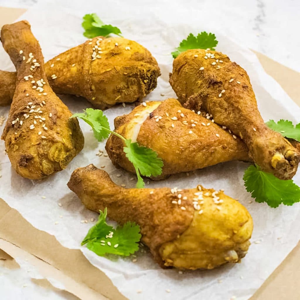 Keto chicken drumsticks on baking paper.