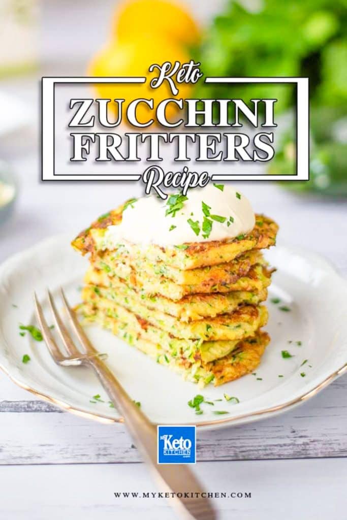 Keto zucchini fritters sliced on a white plate with lemon and parsley in the background.