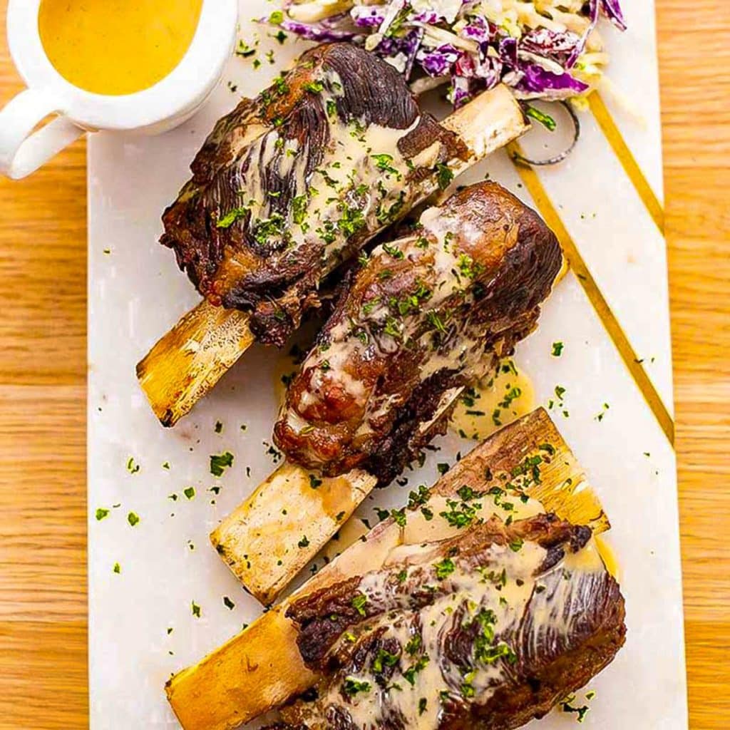 Beef short ribs on a chopping board.